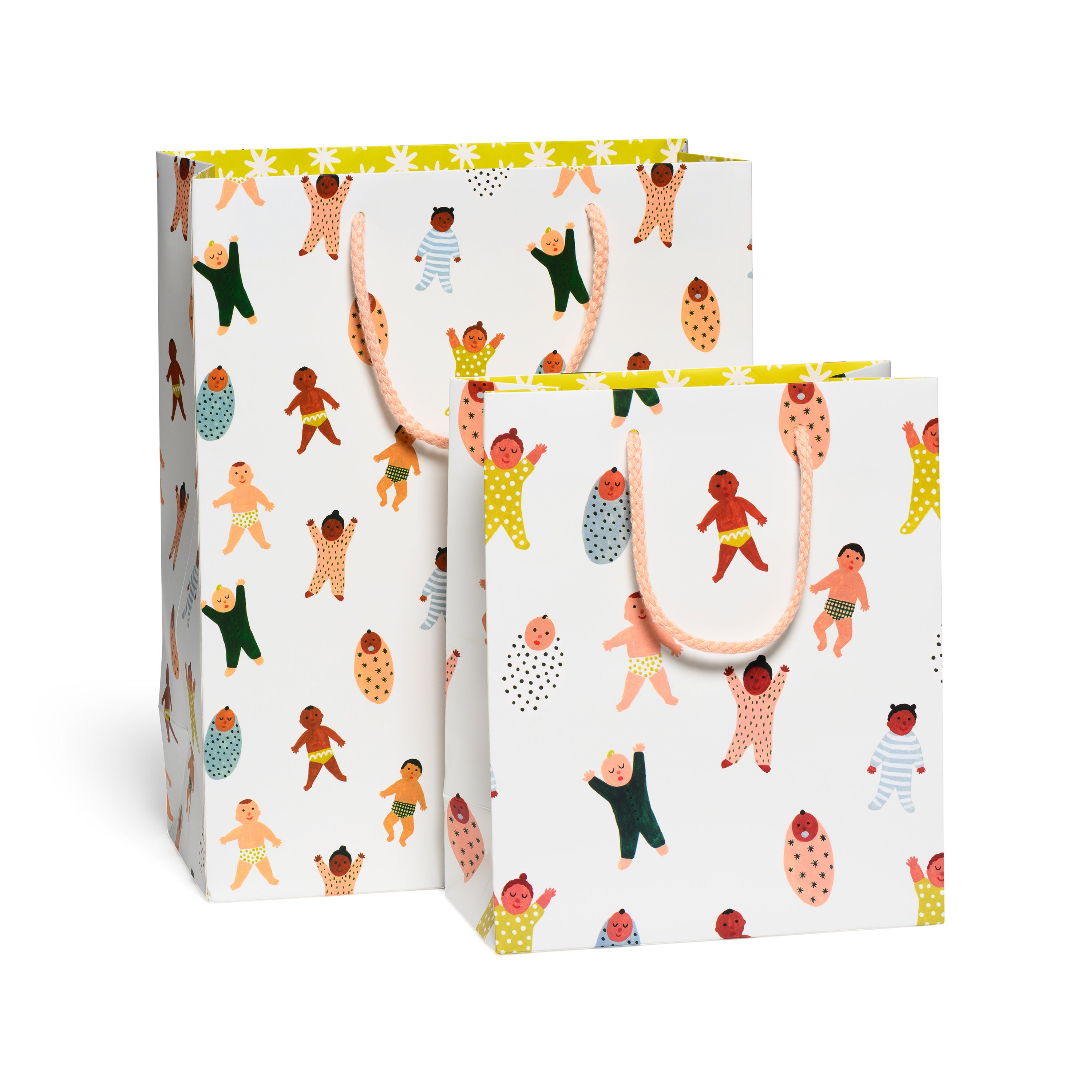 Two paper gift bags with a printed pattern featuring illustrated babies tied with peach colored cotton rope handles.