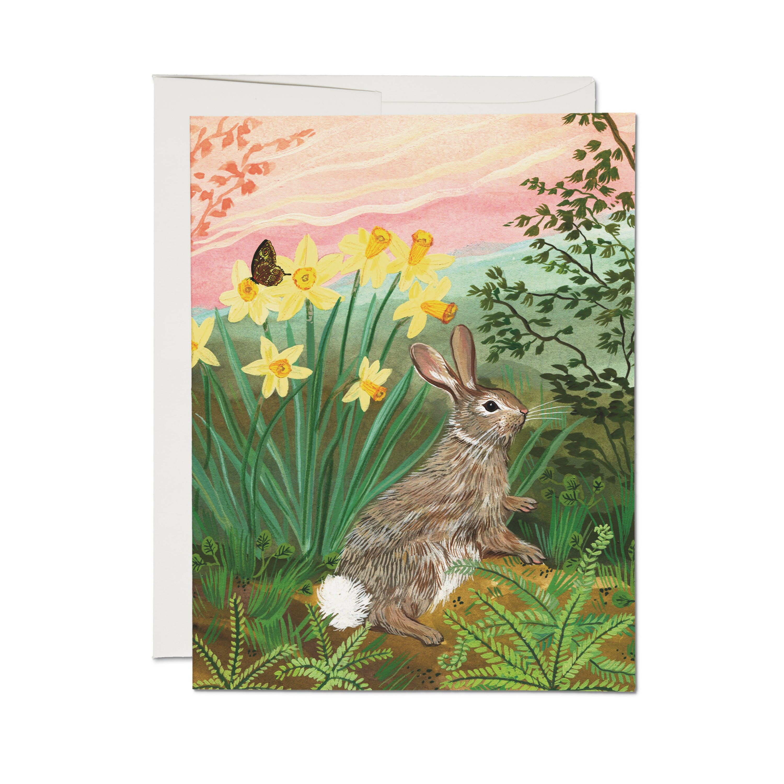 Greeting card with a rabbit and daffodils in a garden setting.