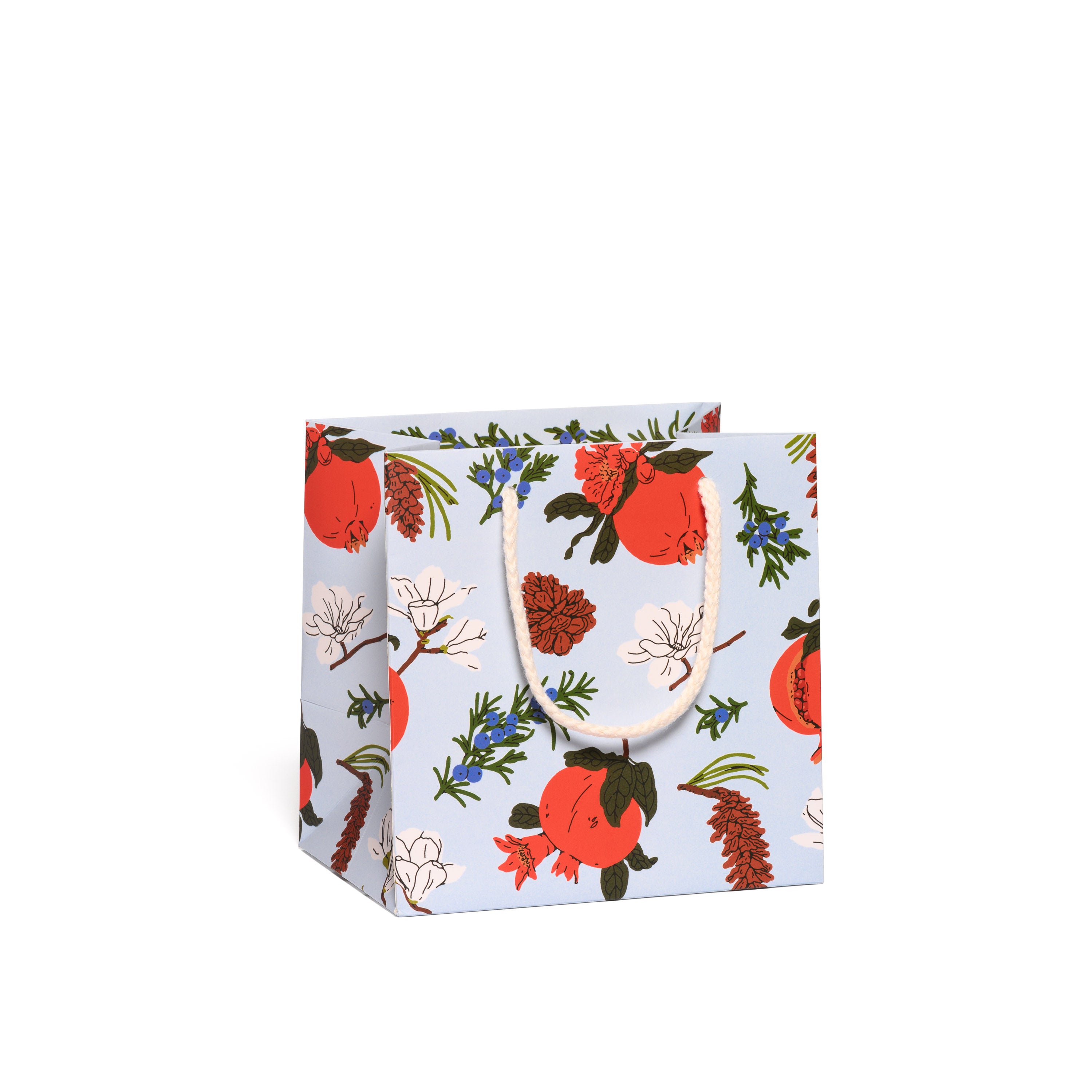 Gift bag with floral and pomegranate design on a light blue background.