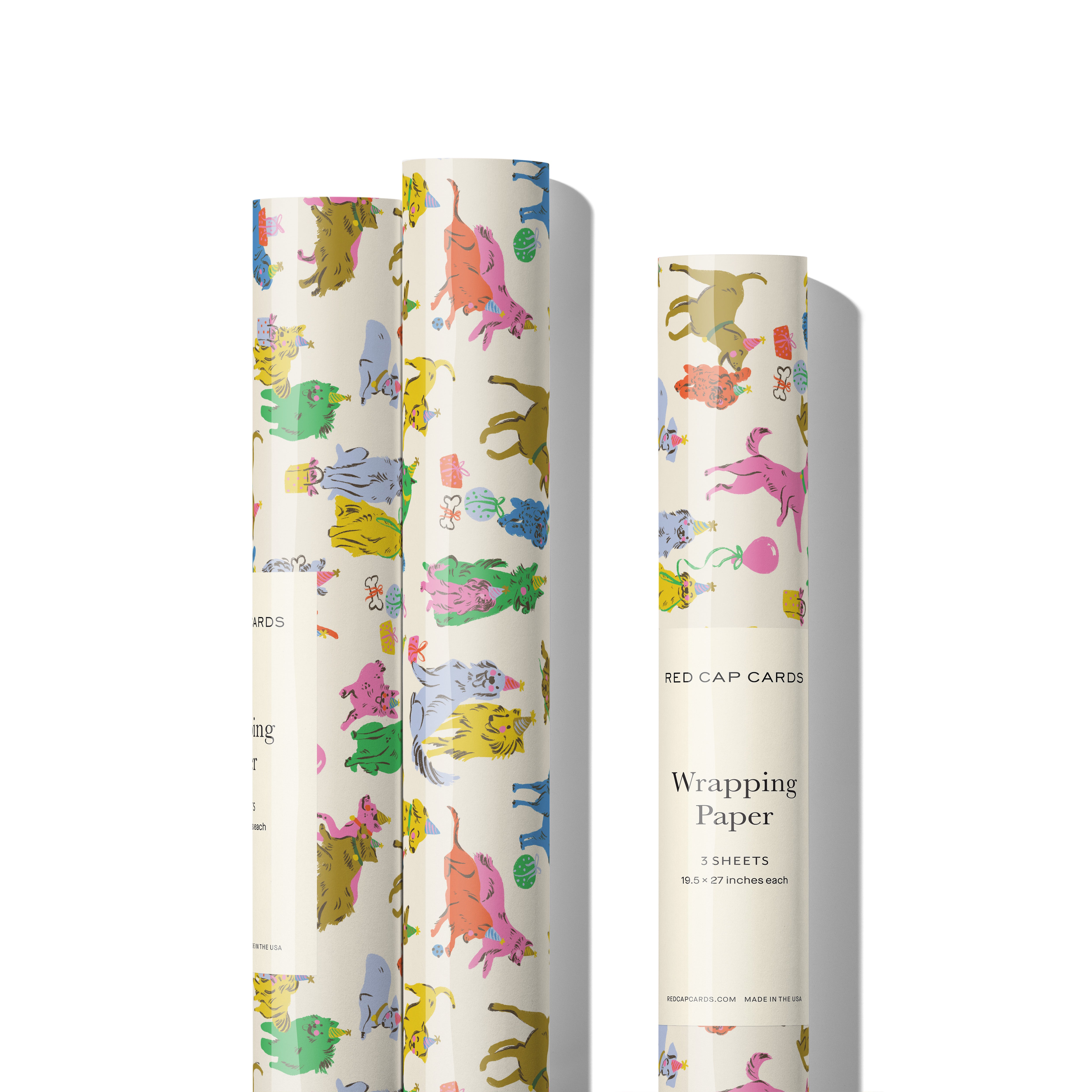 Three rolls of colorful wrapping paper with colorful dog birthday party designs on a white background.