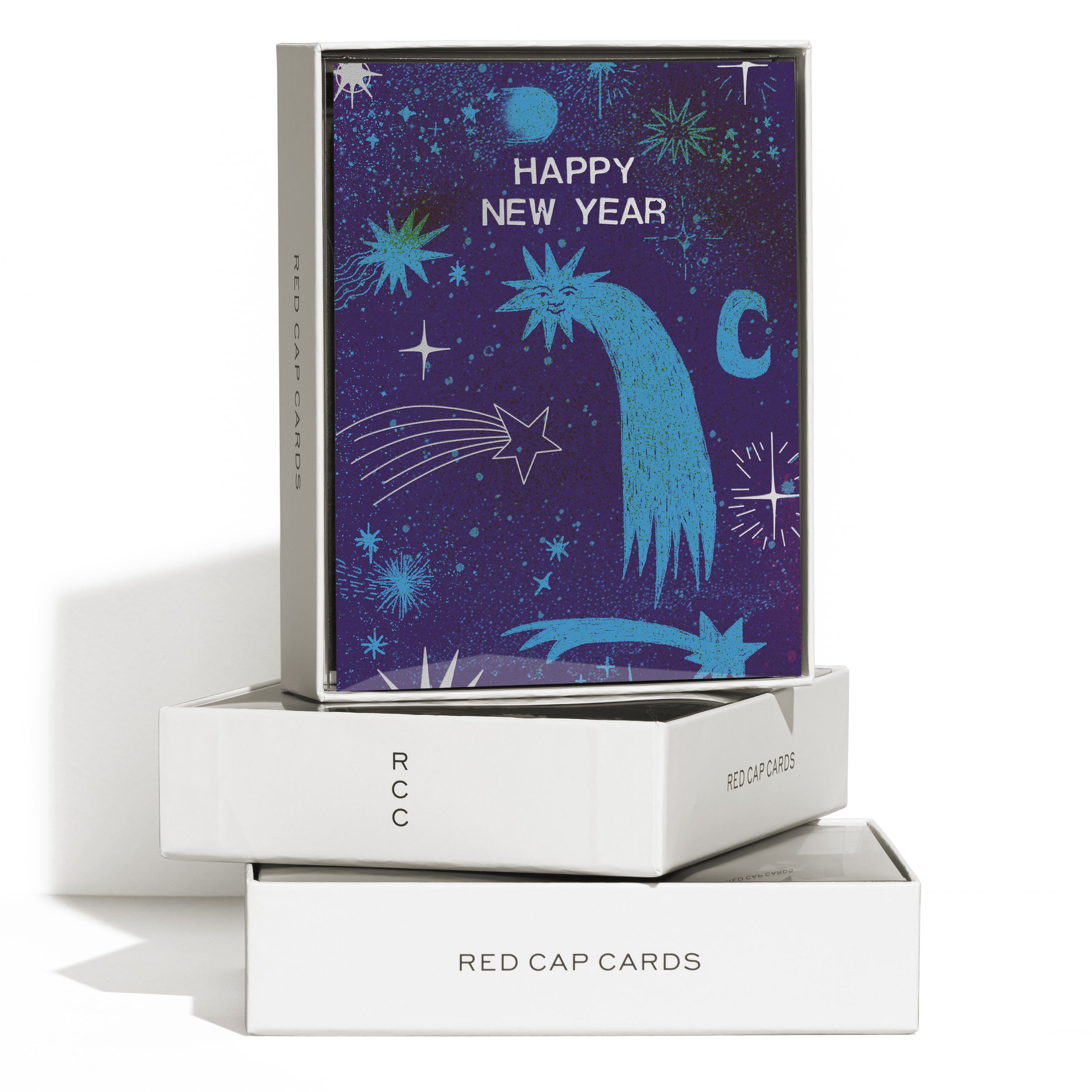 Boxed set of 8 "Happy New Year" greeting cards with shooting stars, one with a face on a navy blue background.