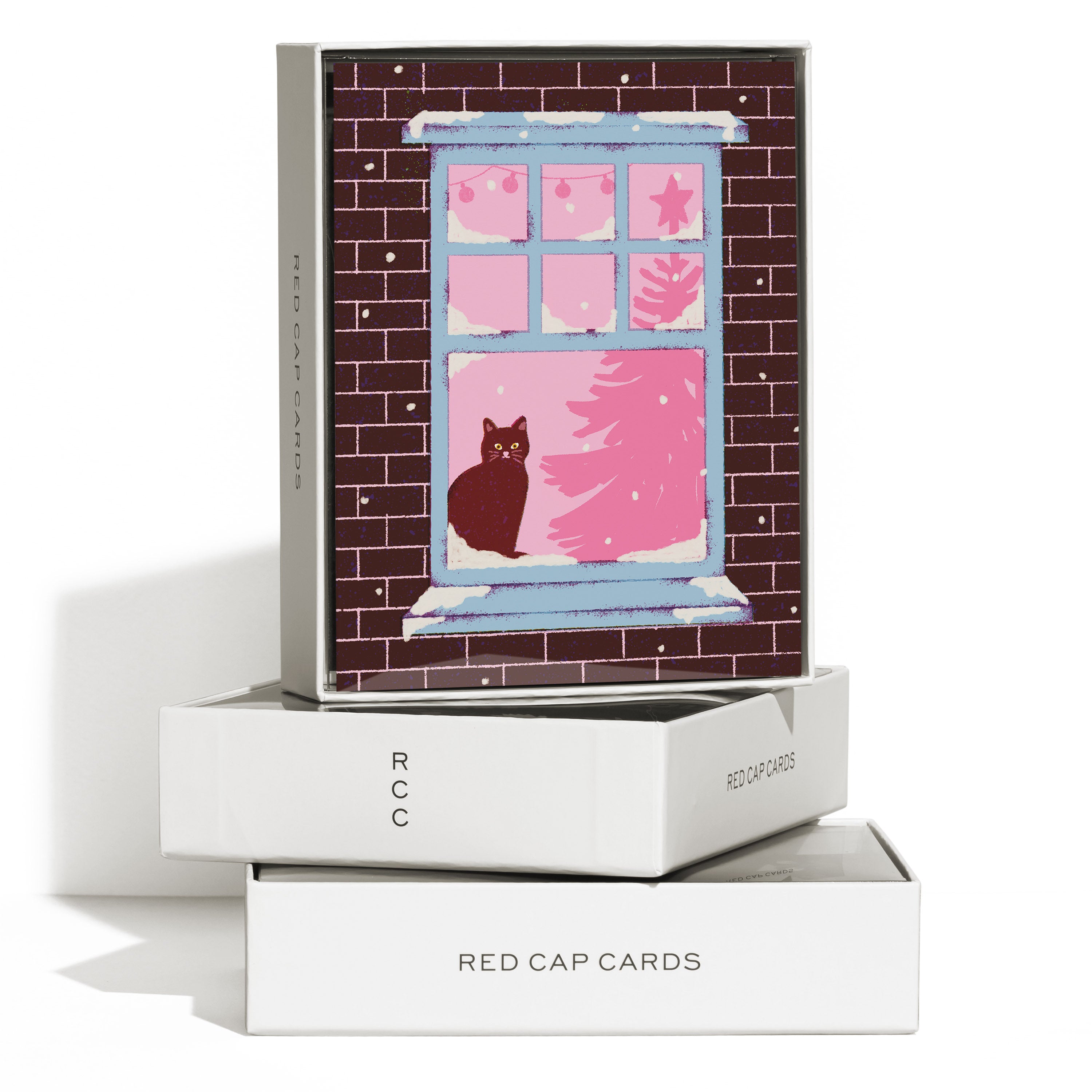 Boxed set of 8 Christmas cards with a cat on a windowsill with a Christmas tree and lights in the background.