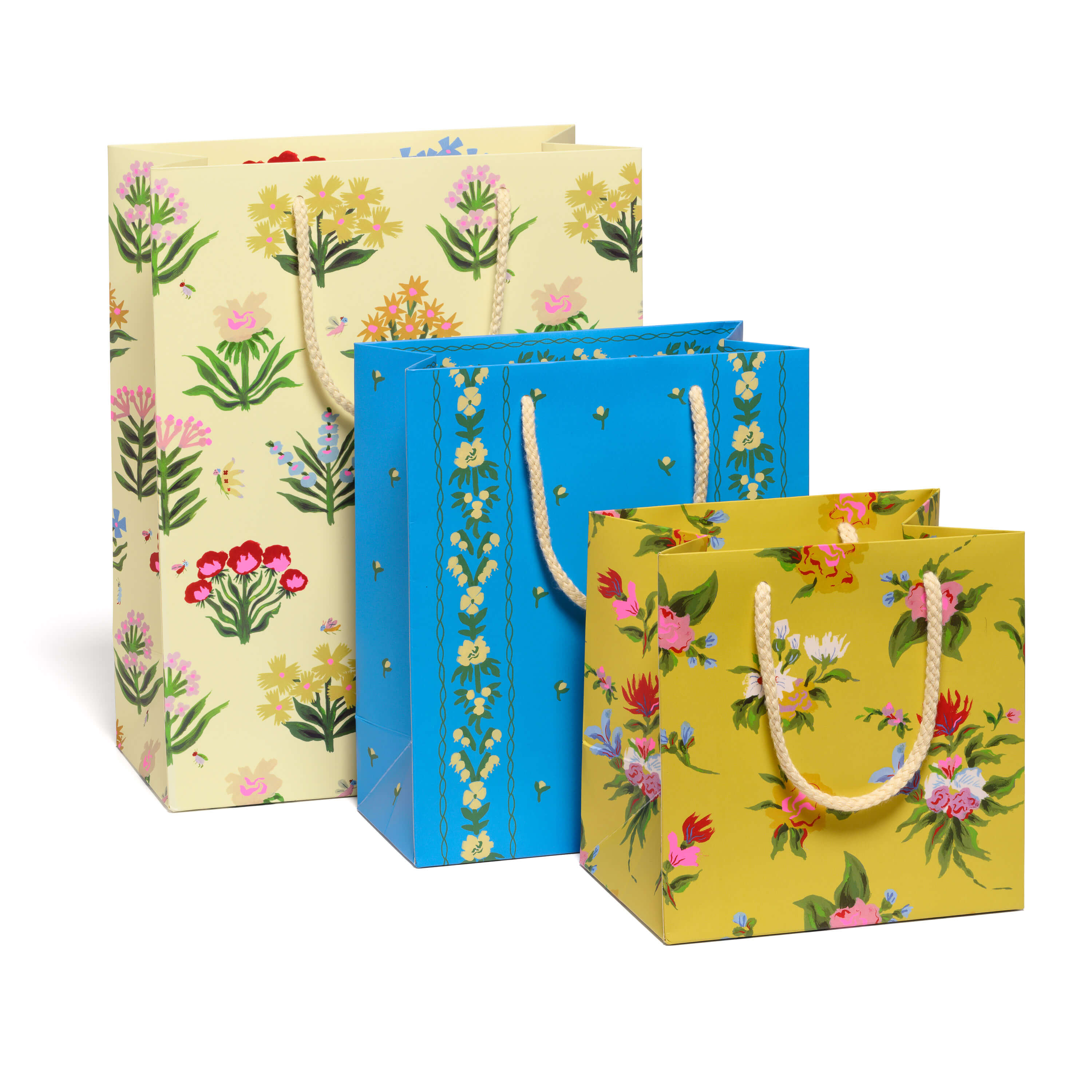 Three floral-patterned gift bags in yellow, blue, and beige on a white background.