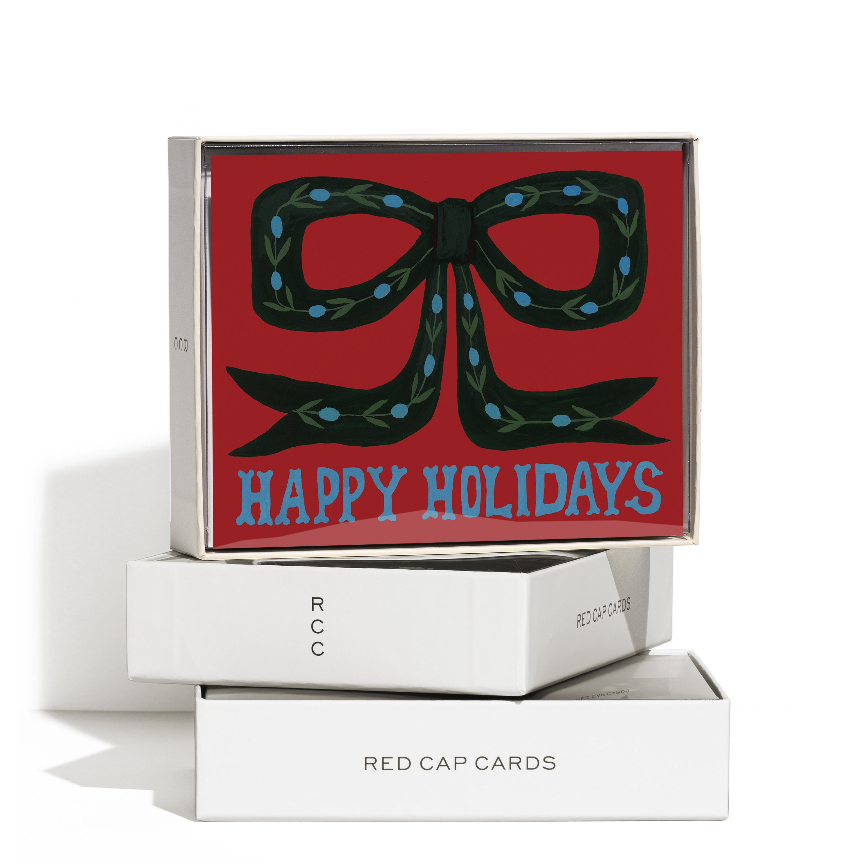 Boxed set of 8 'Happy Holidays' cards with green bow decorated with blue berries and leaves on red background.