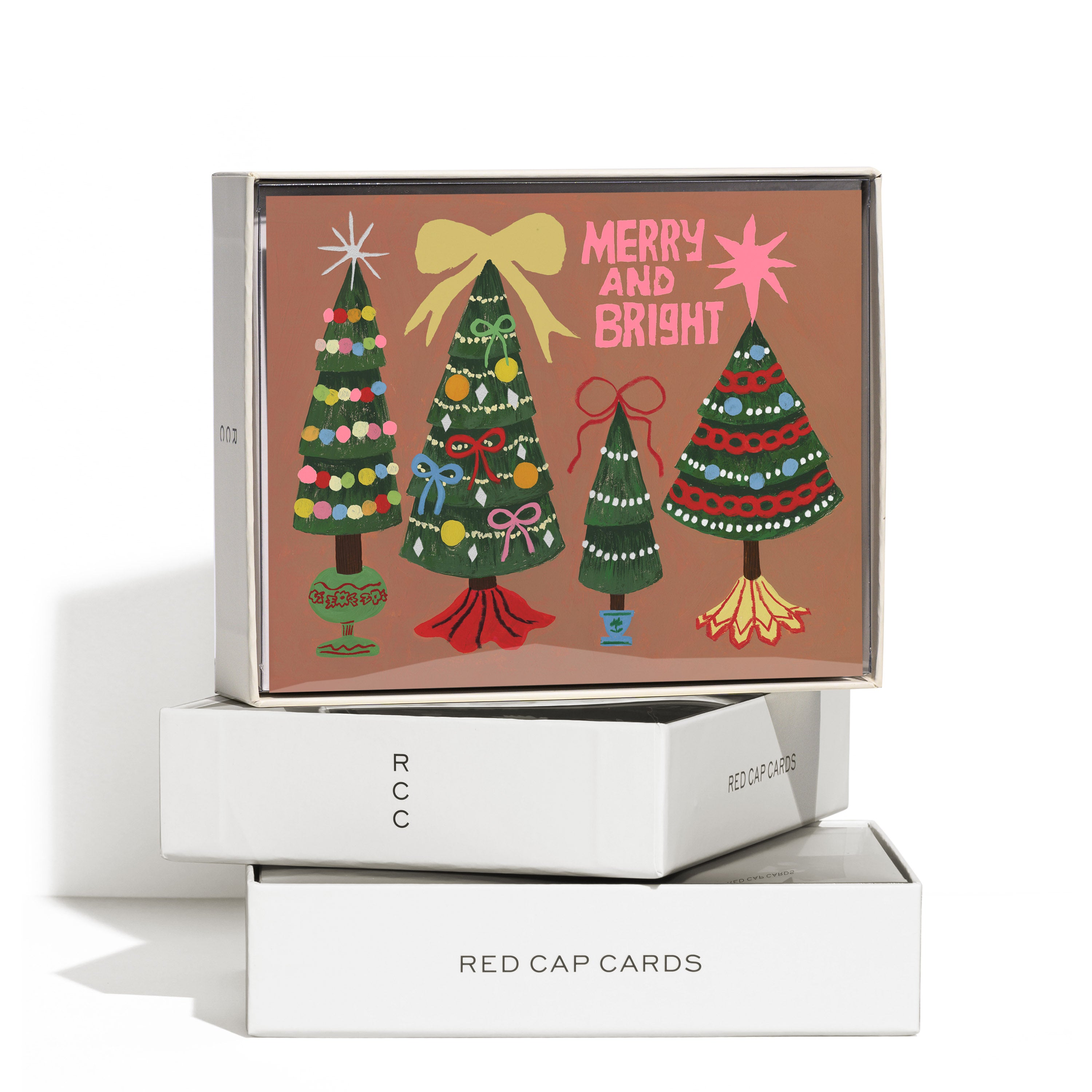 Boxed set of 8 Christmas cards with four decorated trees with stars and bows and "Merry and Bright" text on brown background.
