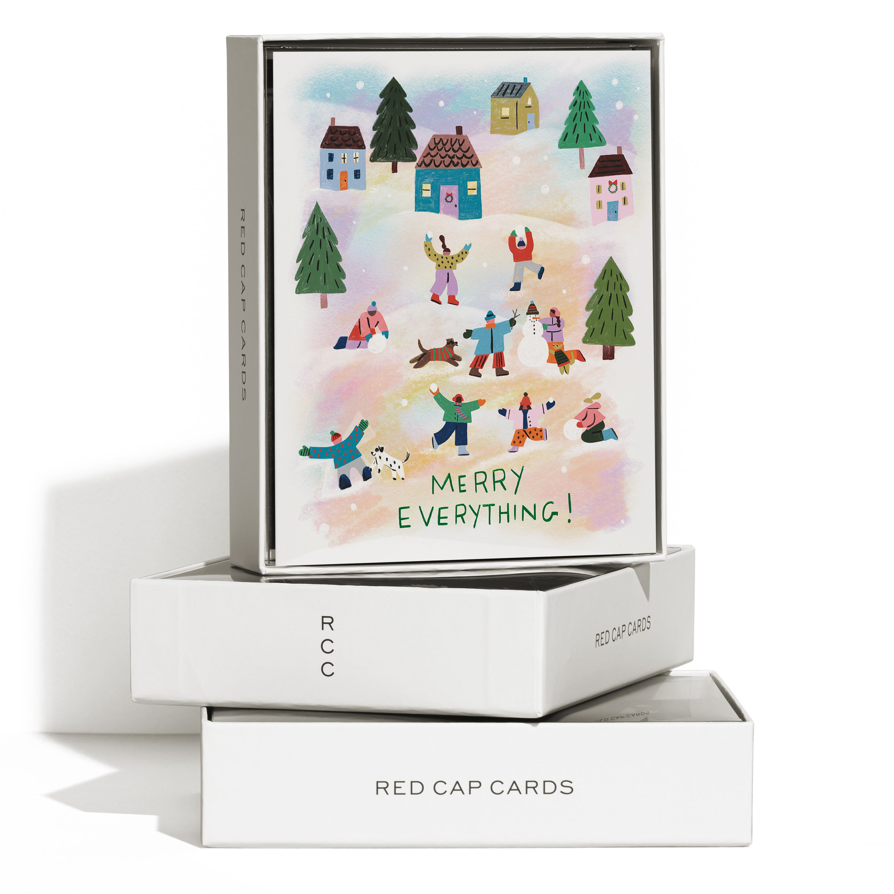 Boxed set of 8 winter greeting cards with people playing in snow, small houses, evergreen trees and 'MERRY EVERYTHING!' text.