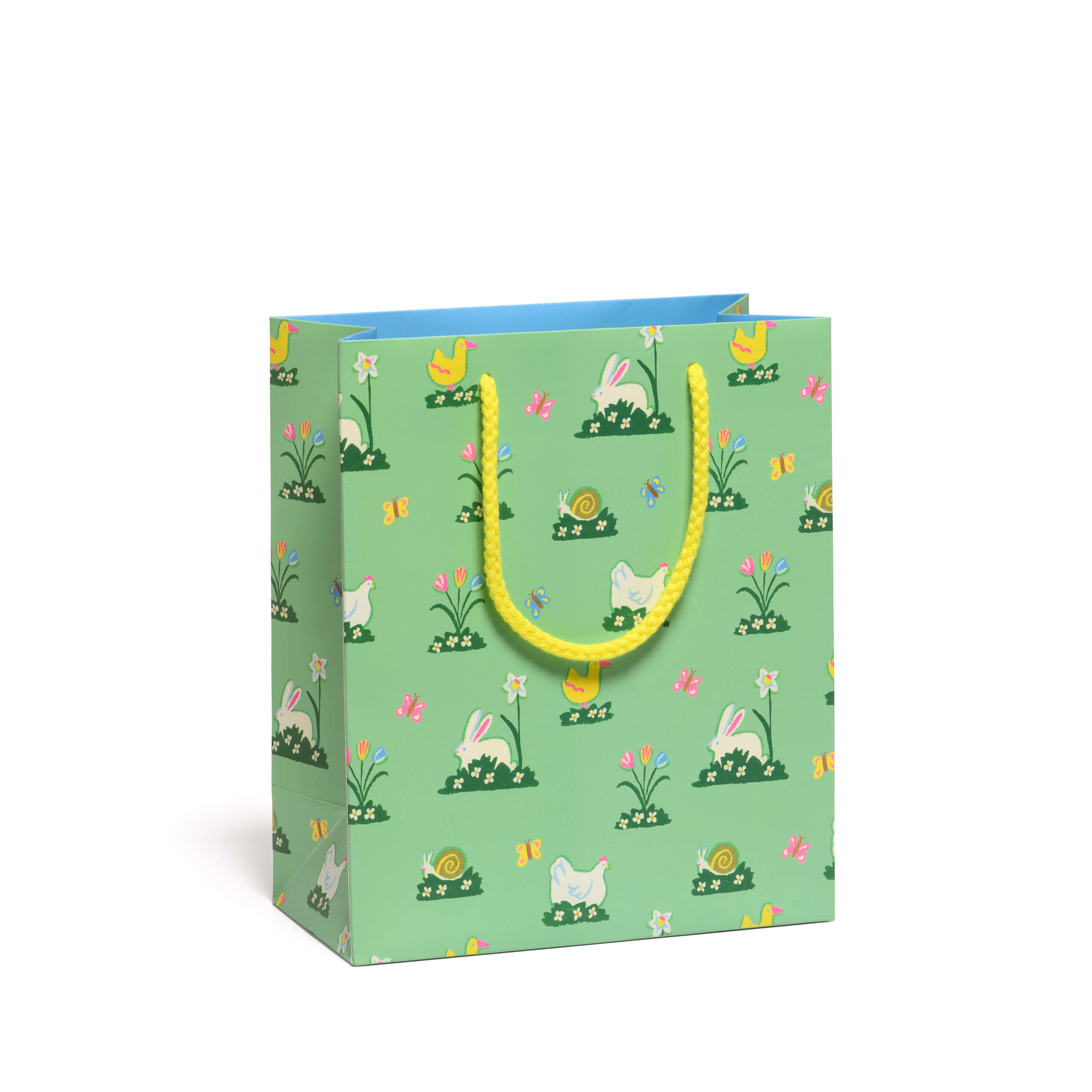 Green gift bag with Easter-themed bunny, chick and tulip illustrations with yellow rope handle on a white background.
