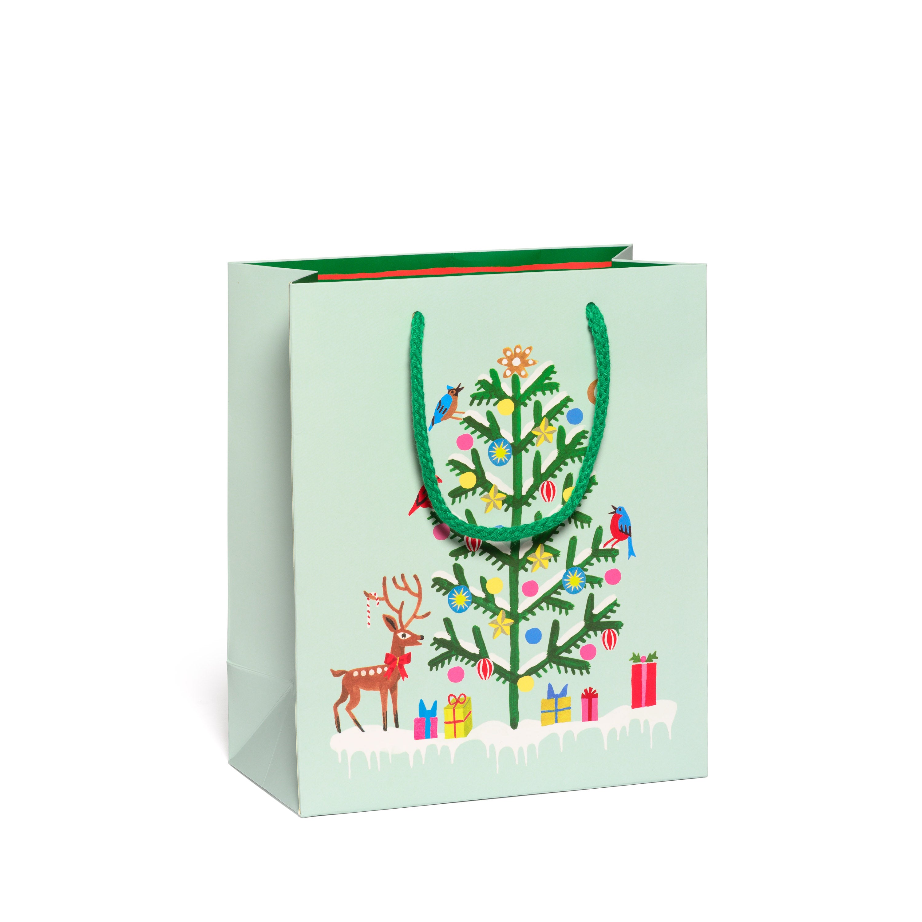 Gift bag with Christmas tree and reindeer design on a light green background.