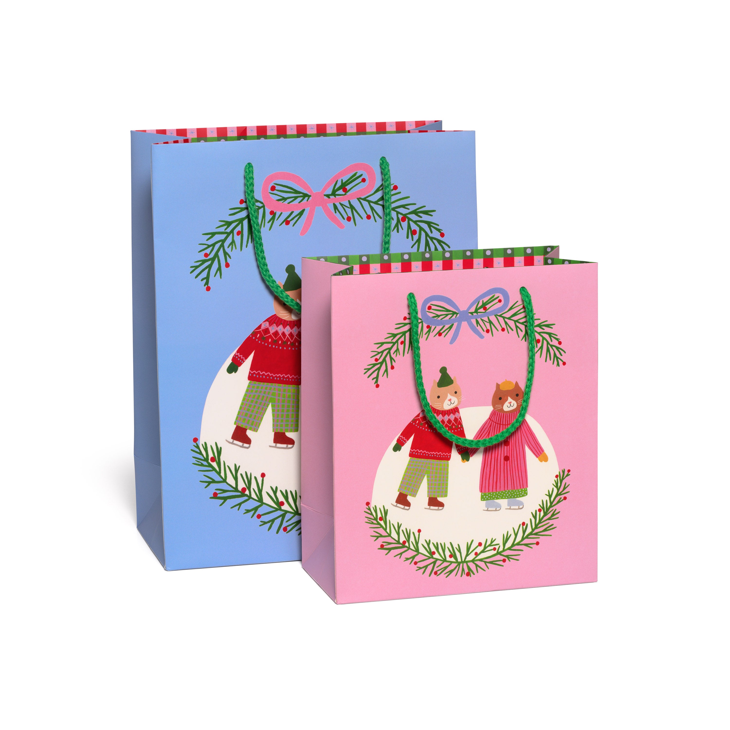Two Christmas-themed gift bags, one blue and one pink, with cartoon cats ice skating holding hands on a white background.