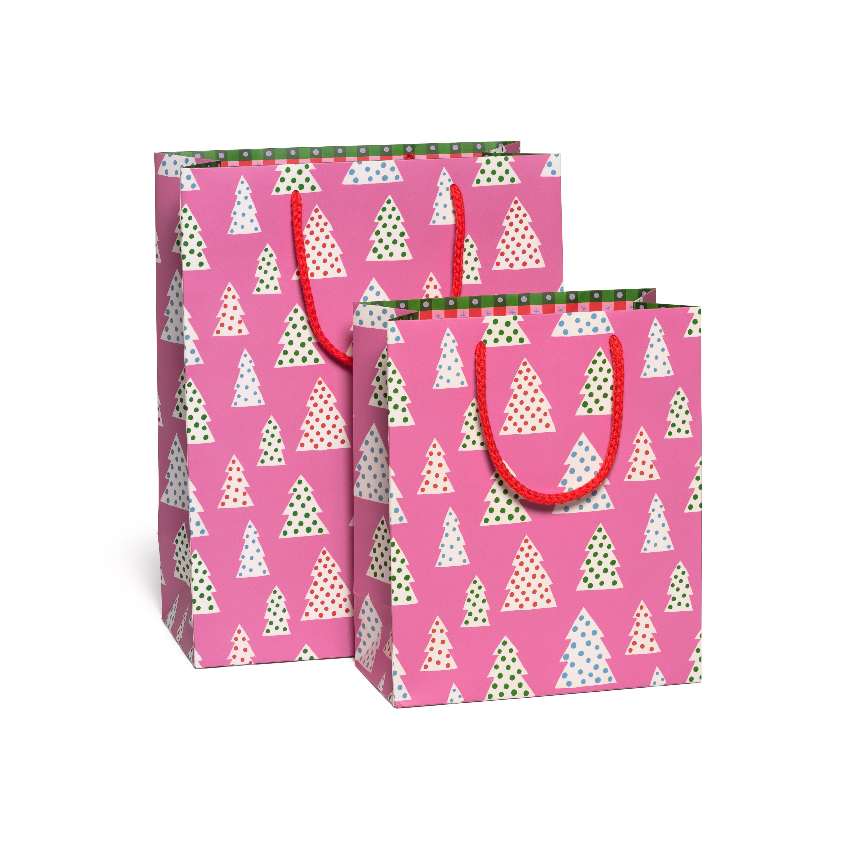 Two pink gift bags with Christmas tree and polka dot pattern on a white background.