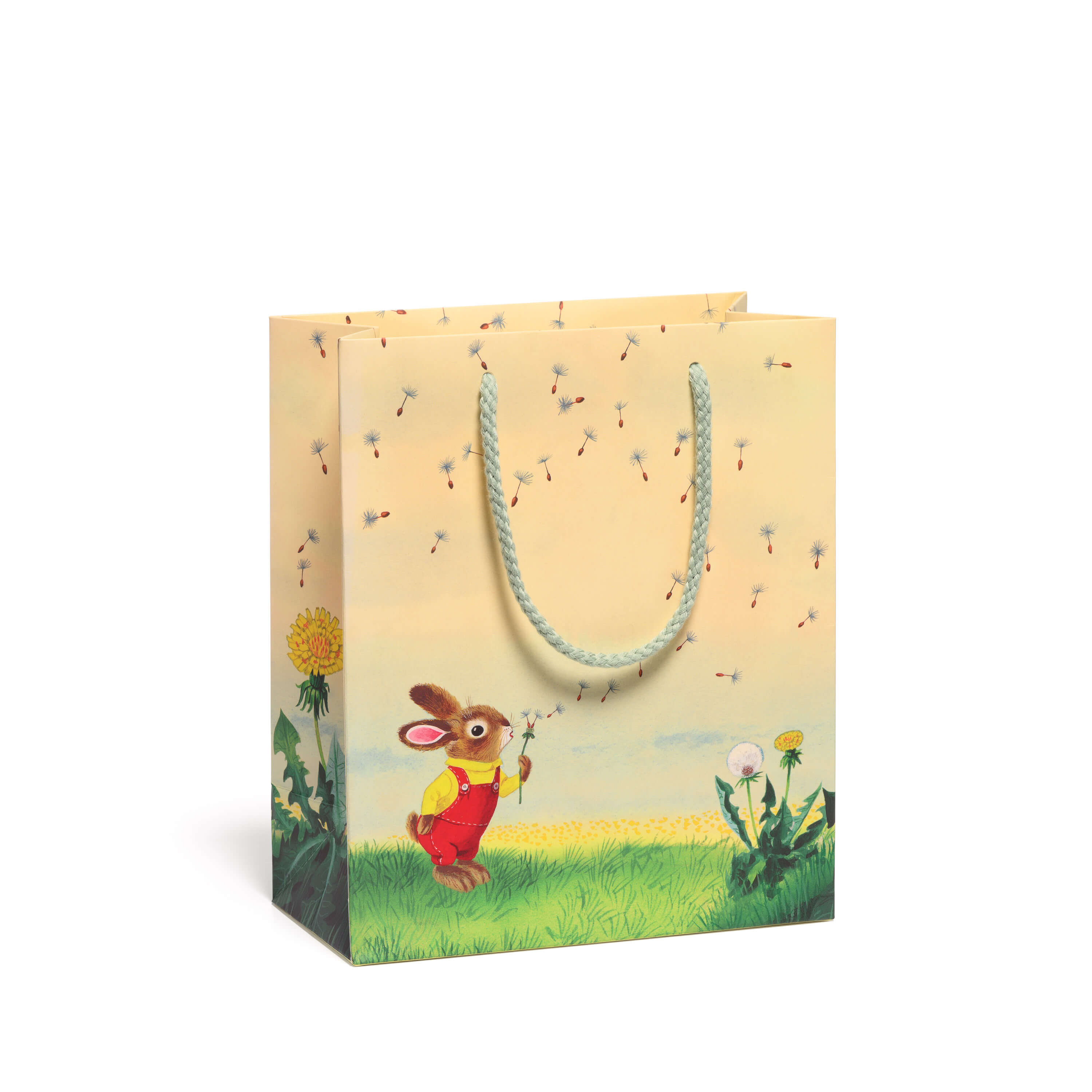 Gift bag with a cartoon bunny blowing a dandelion seed head in a grassy field on a white background.