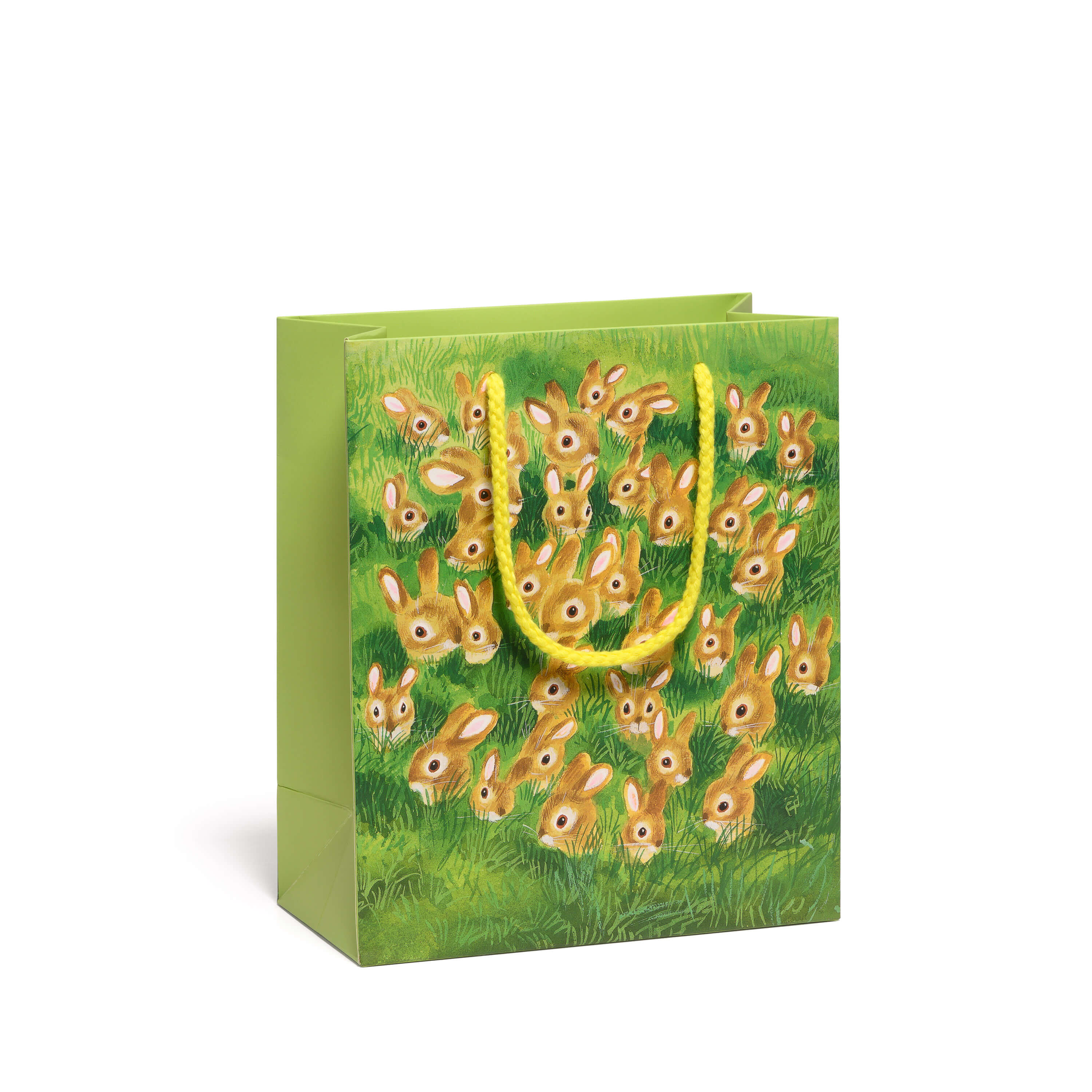 Gift bag with design of multiple illustrated rabbits in a green grassy field with a yellow rope handle on a white background.
