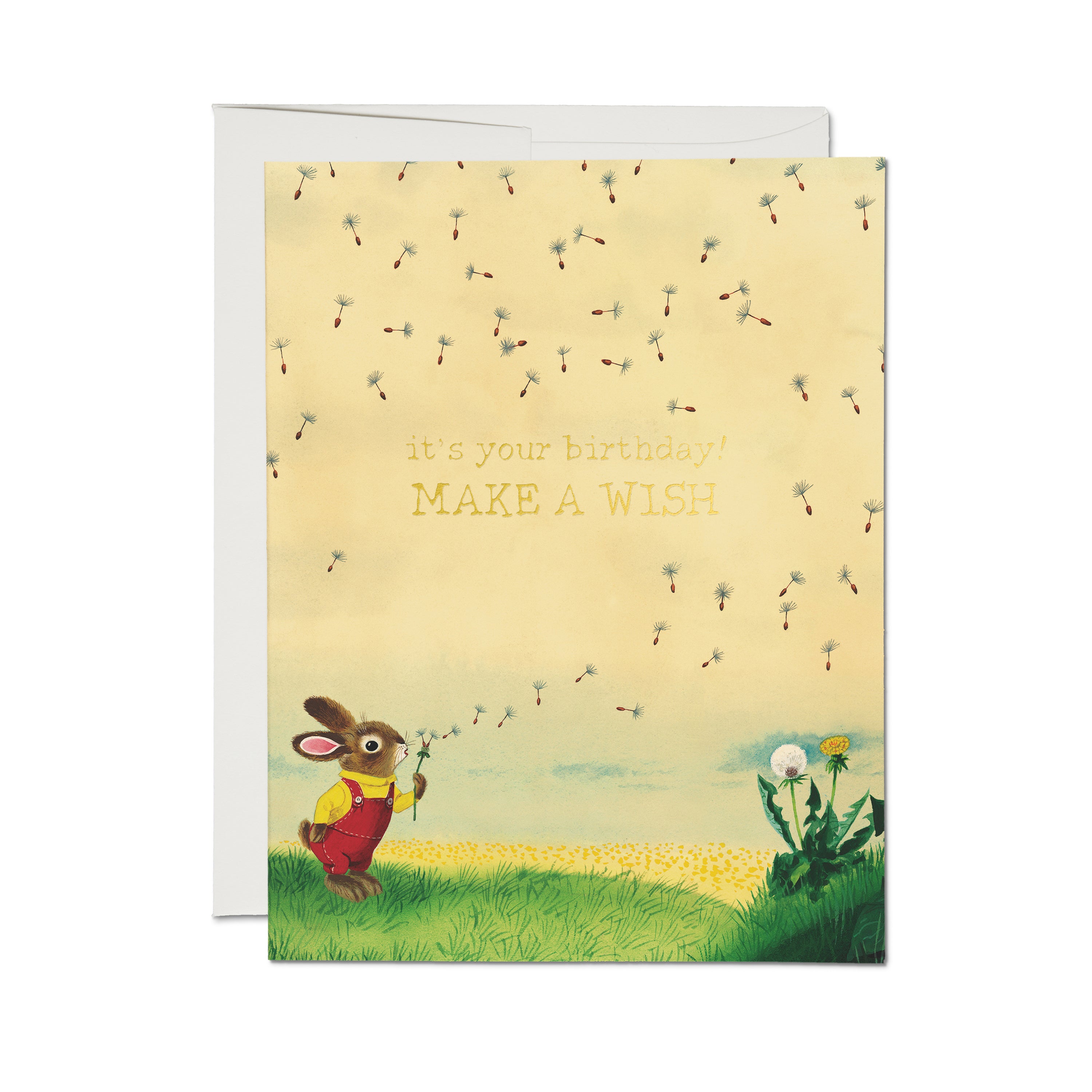 Birthday card with cartoon bunny blowing. dandelion in a grassy field with "it's your birthday! MAKE A WISH" text.