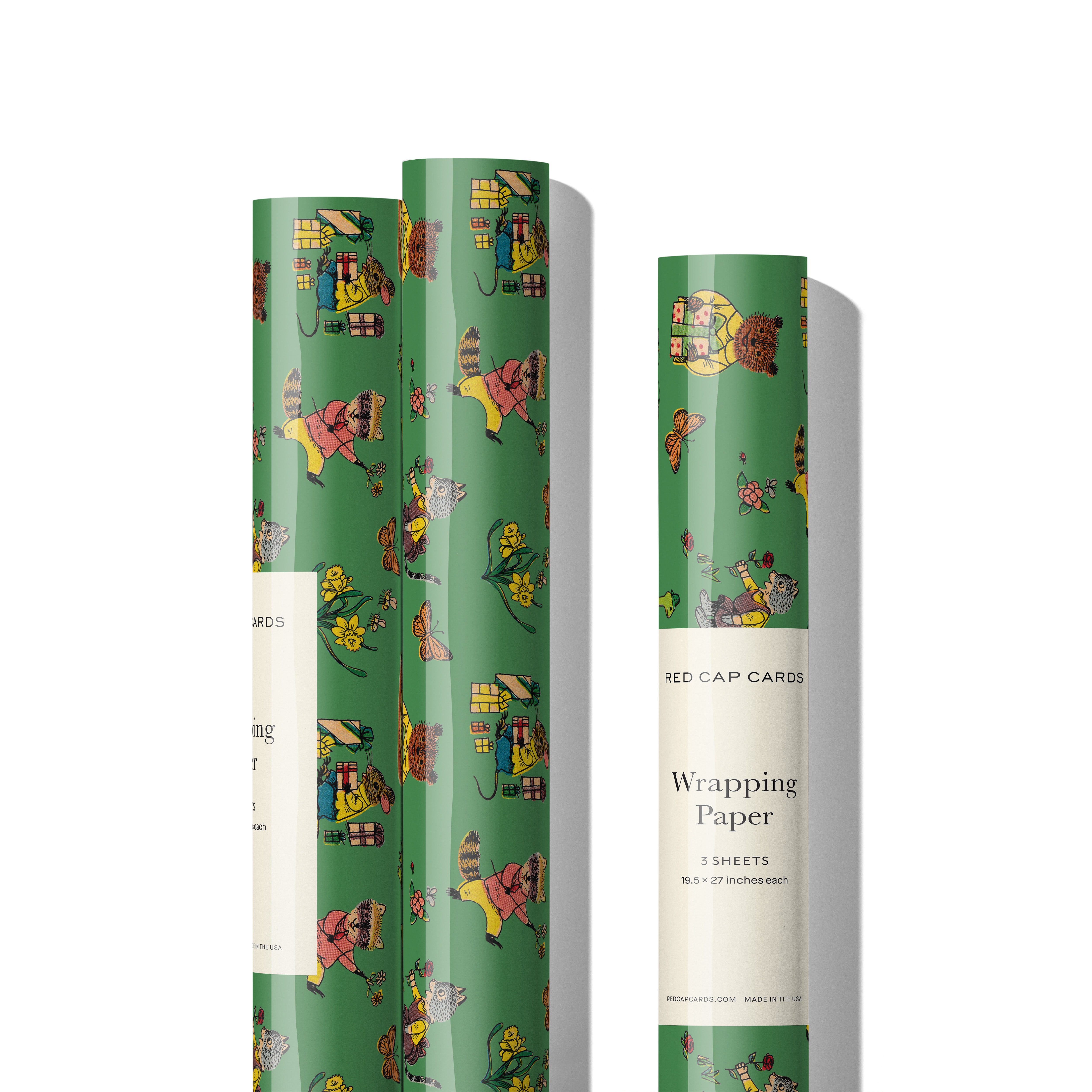 Three rolls of birthday themed Gift wrap with woodland animal illustrations with presents, cake and flowers on a green background.