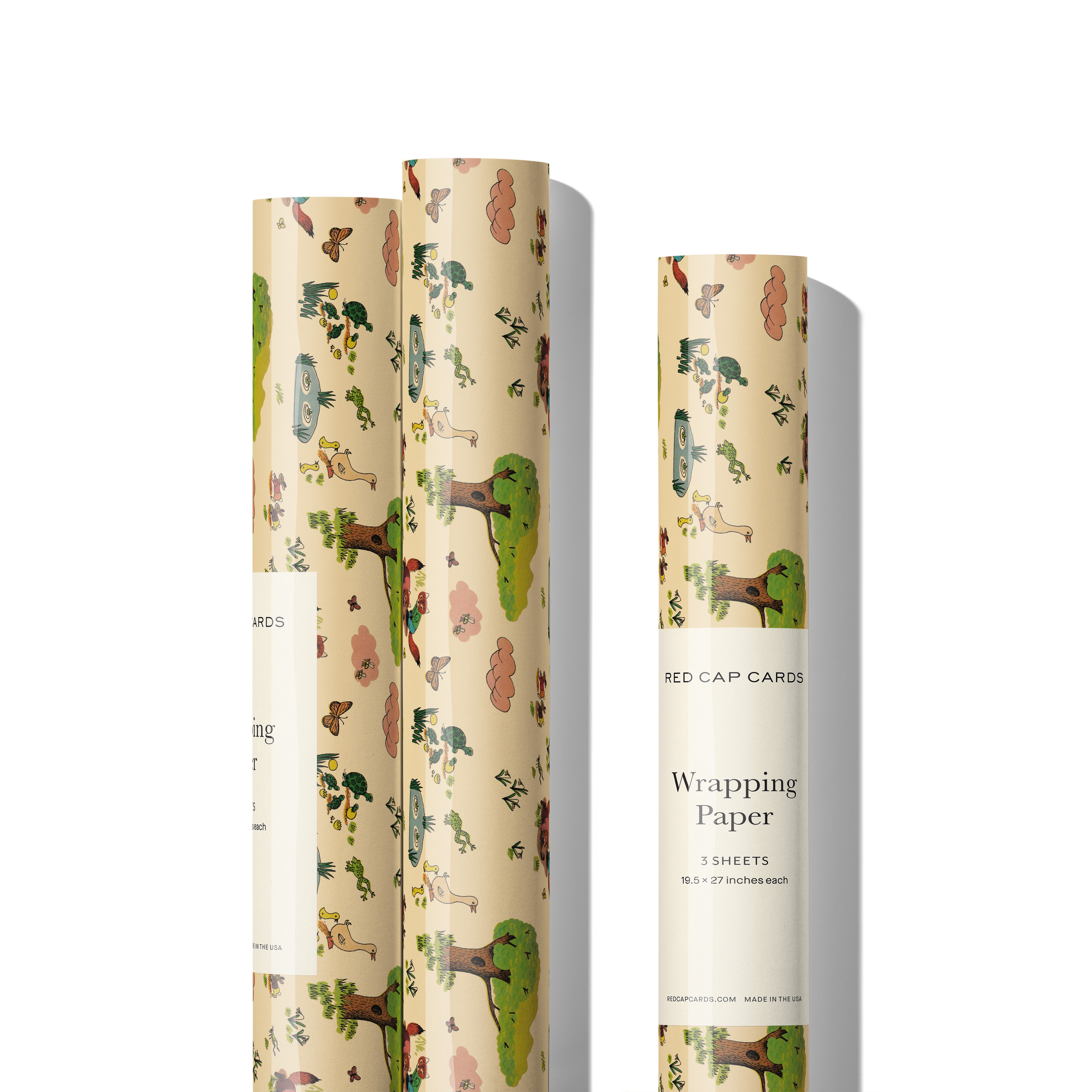 Three rolls of gift Wrap with illustrated pattern of woodland animals in a forest on a beige background.