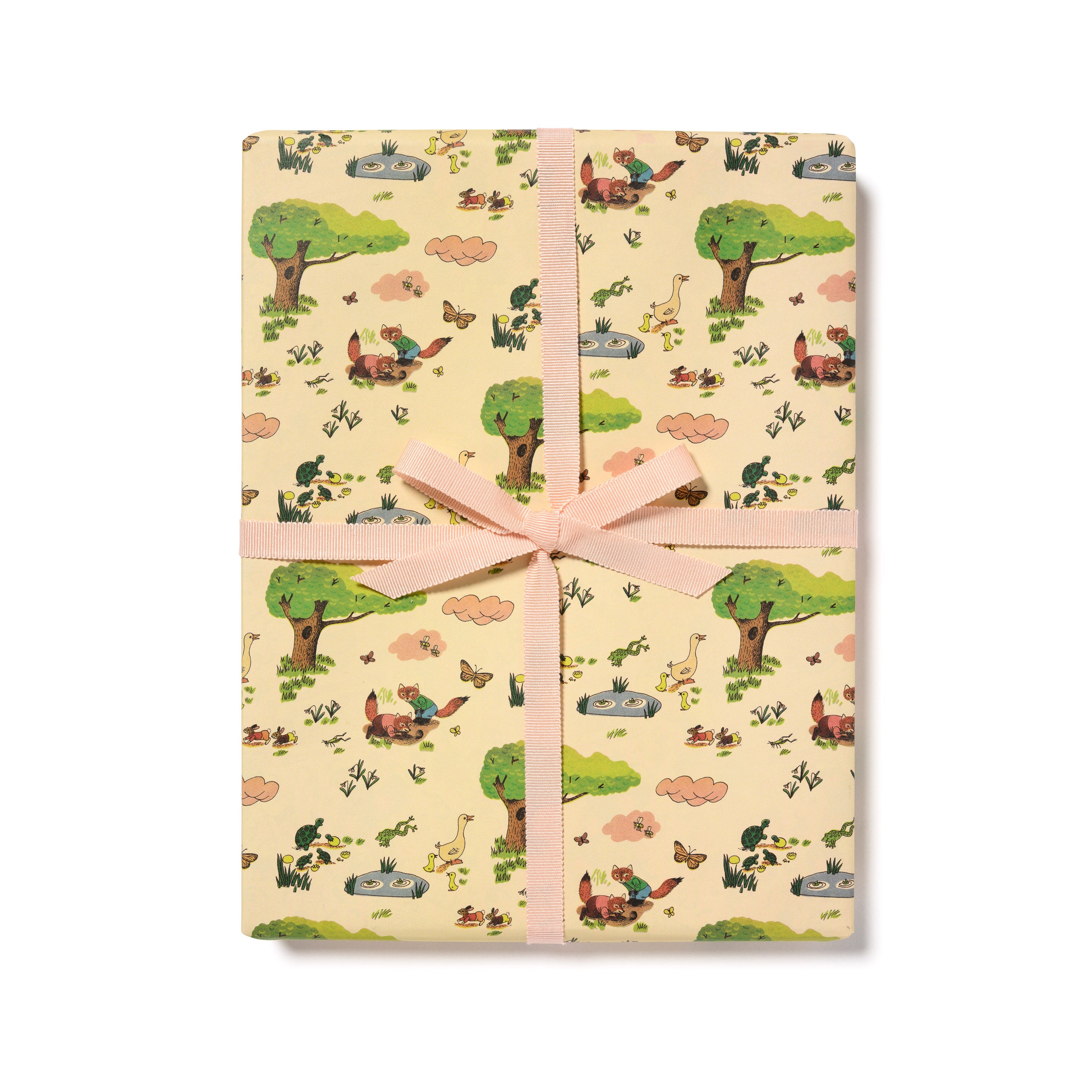 Gift Wrap with illustrated pattern of woodland animals in a forest on a beige background with a pink ribbon.