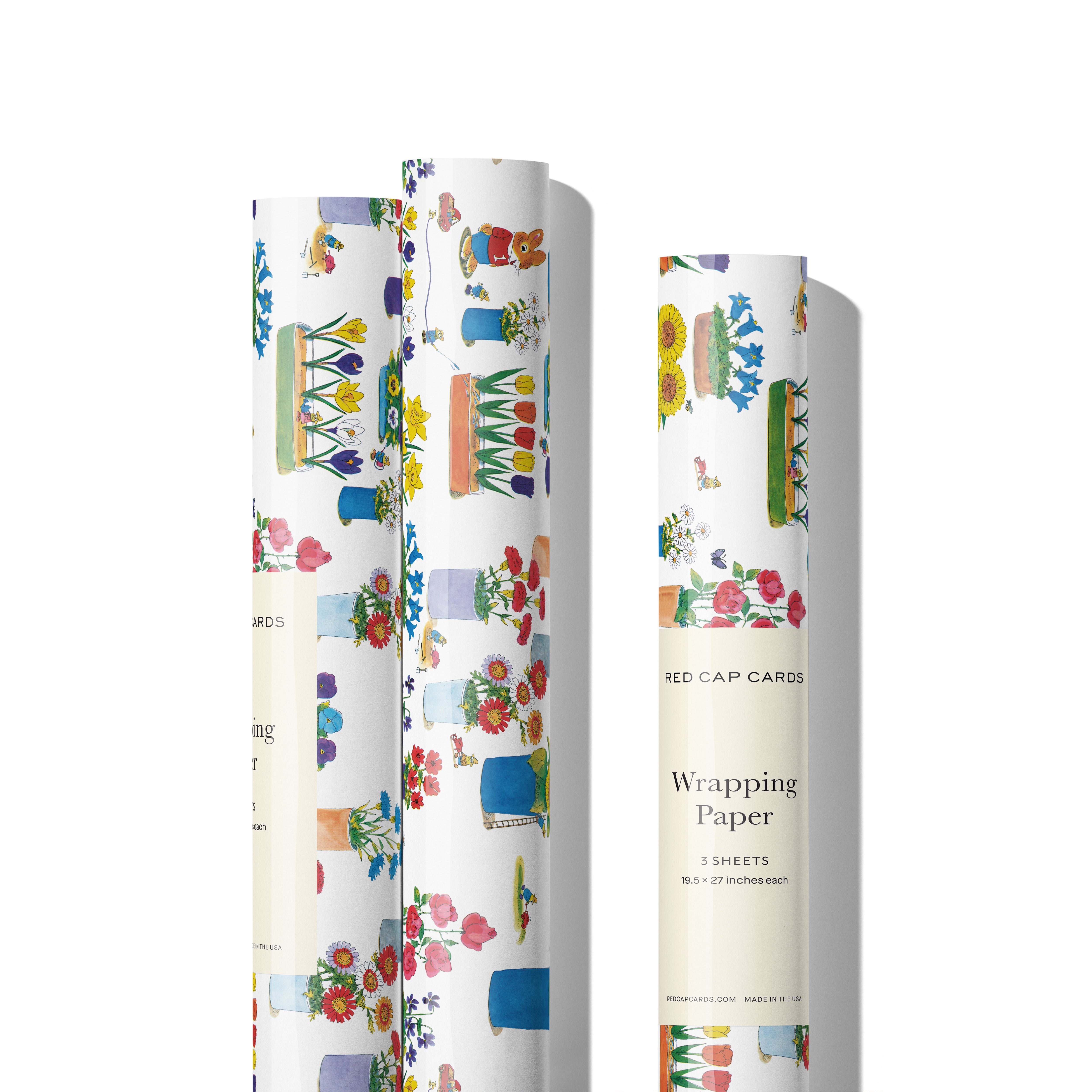 Three rolls of gift wrap with colorful floral and garden design on a white background.