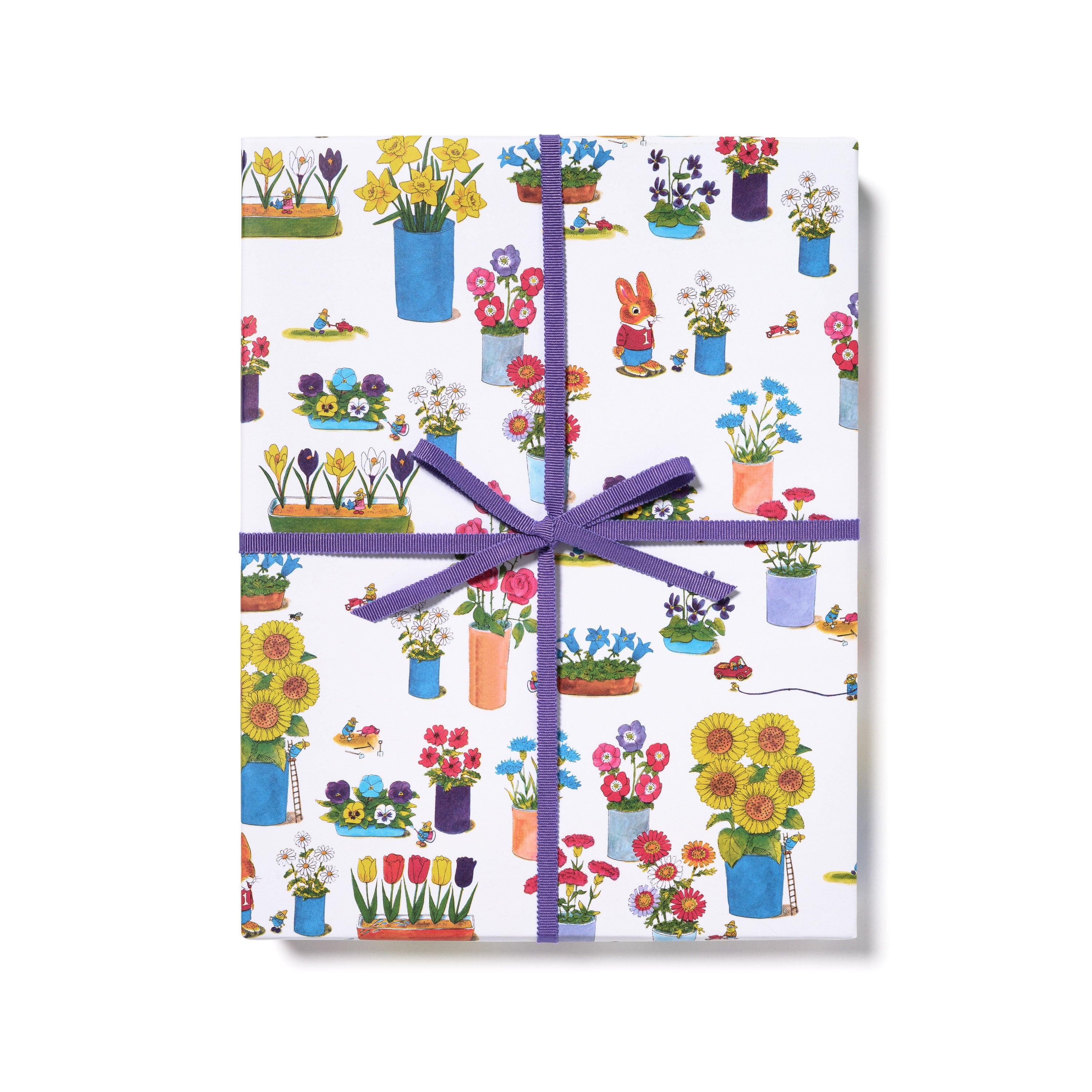 Gift wrap with colorful floral and garden design tied with a purple ribbon on a white background.