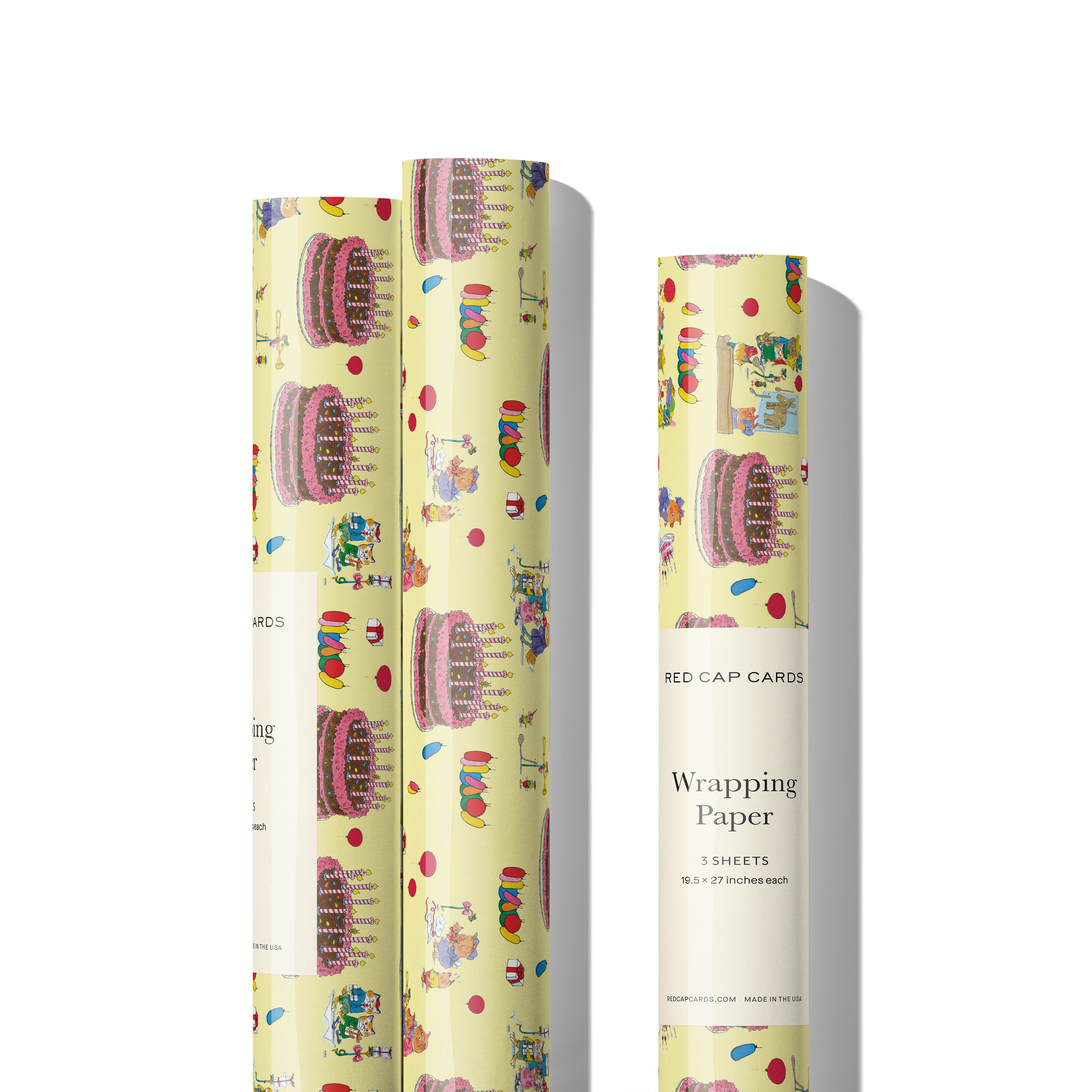 Three rolls of gift wrap with animal illustrations and party themes with a giant cake on a yellow background. 