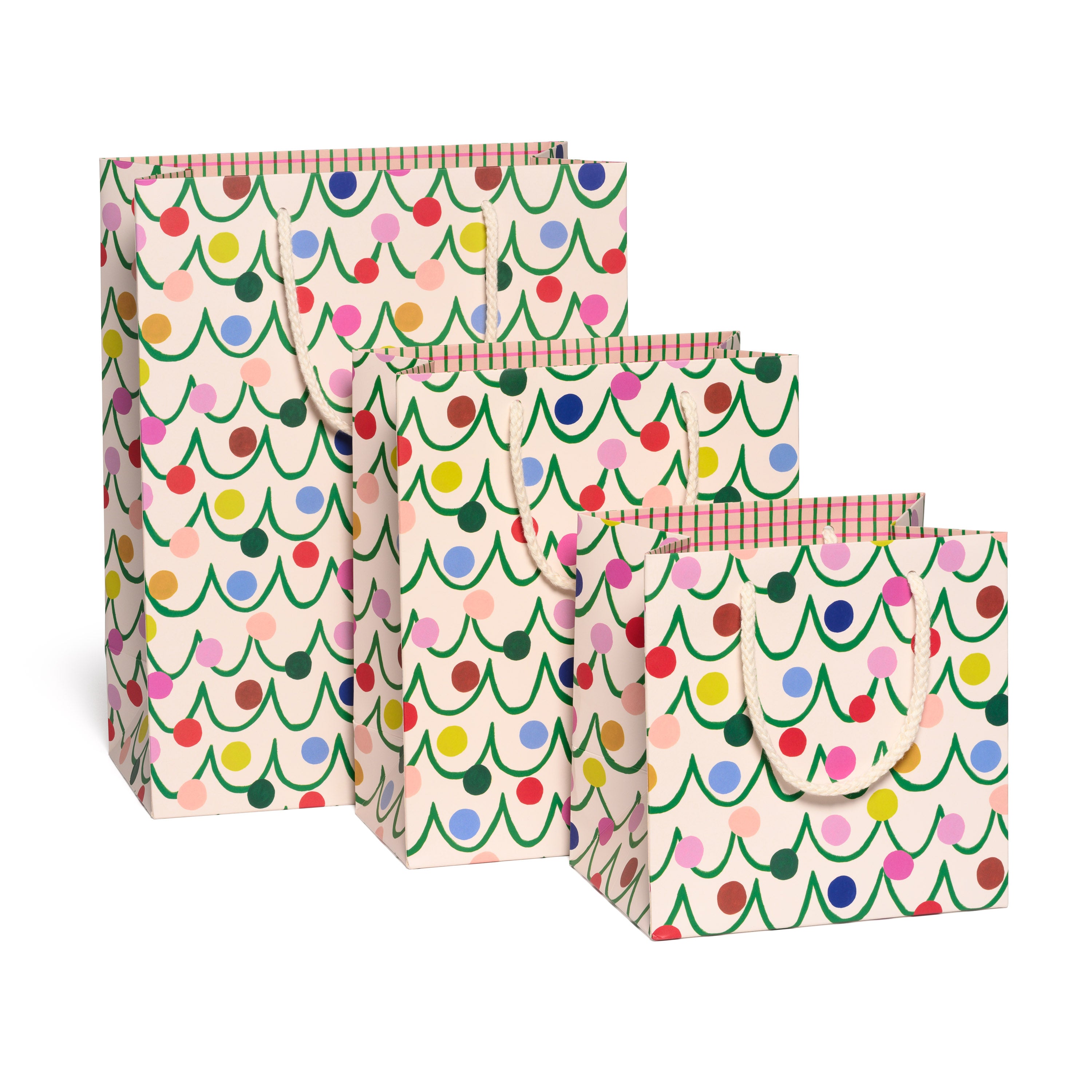 Set of three gift bags with colorful Christmas tree pattern on a white background.