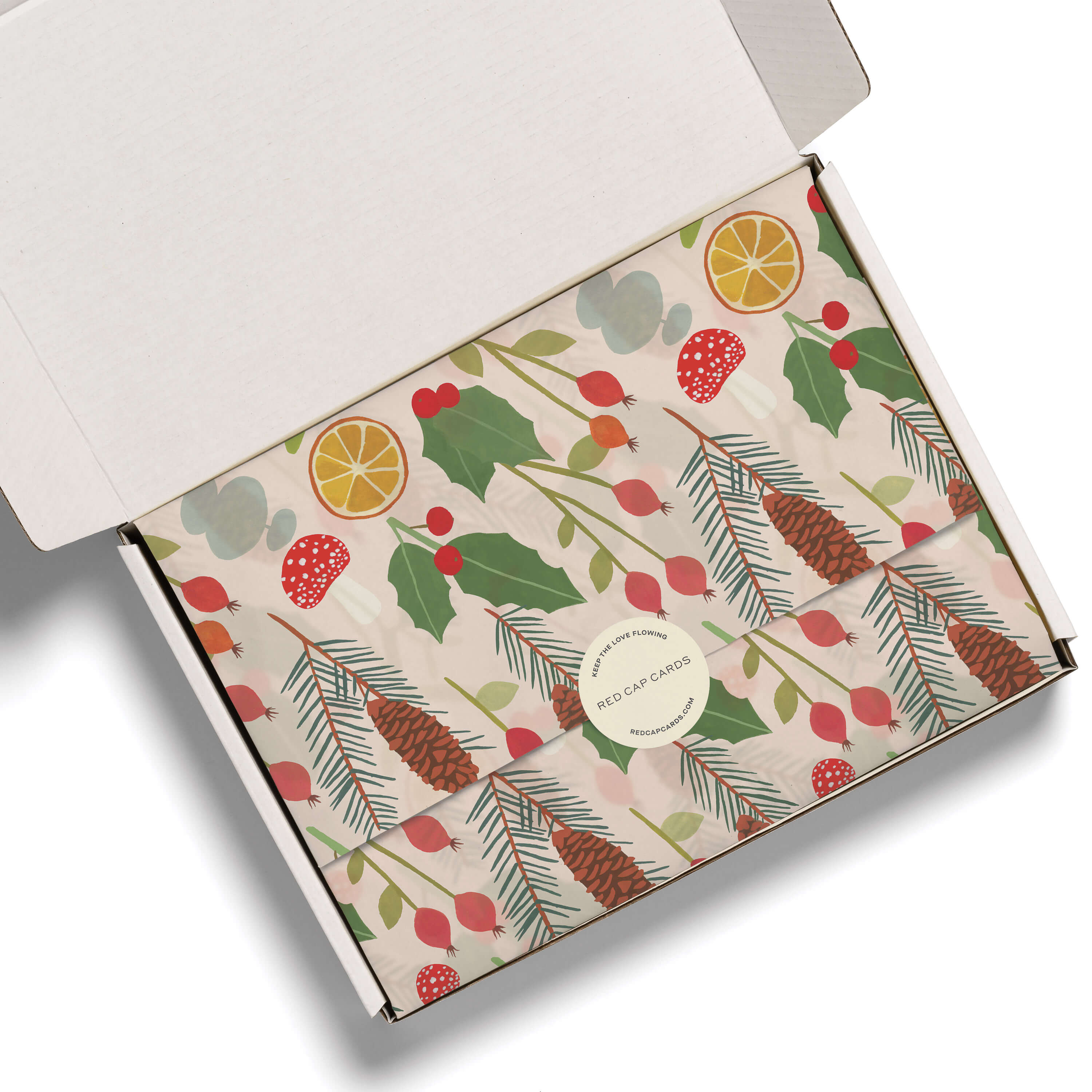 Tissue paper with a colorful illustrated holiday floral theme print in a white box on a white background.