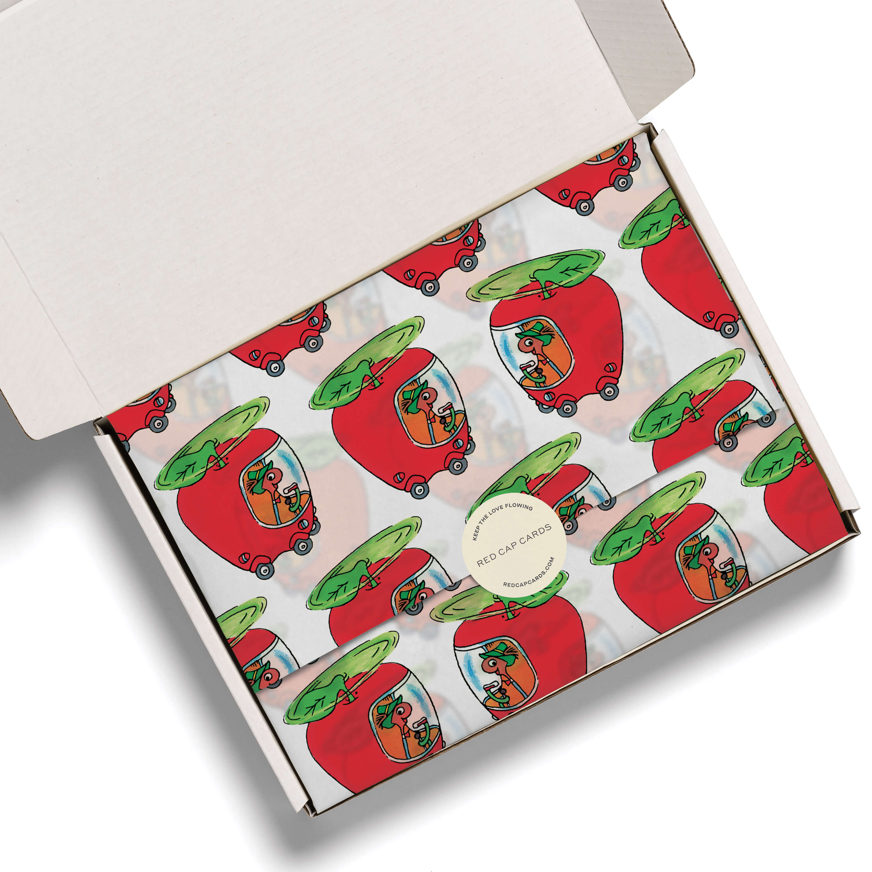 Lowly Worm Apple Car tissue paper in a white gift box on a white background.
